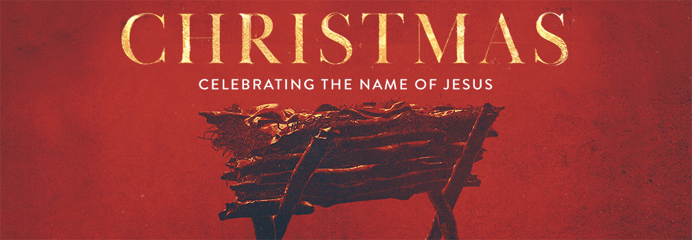 Red background with a wooden manager in the middle of the image. Text says: Christmas, celebrating the name of Jesus.