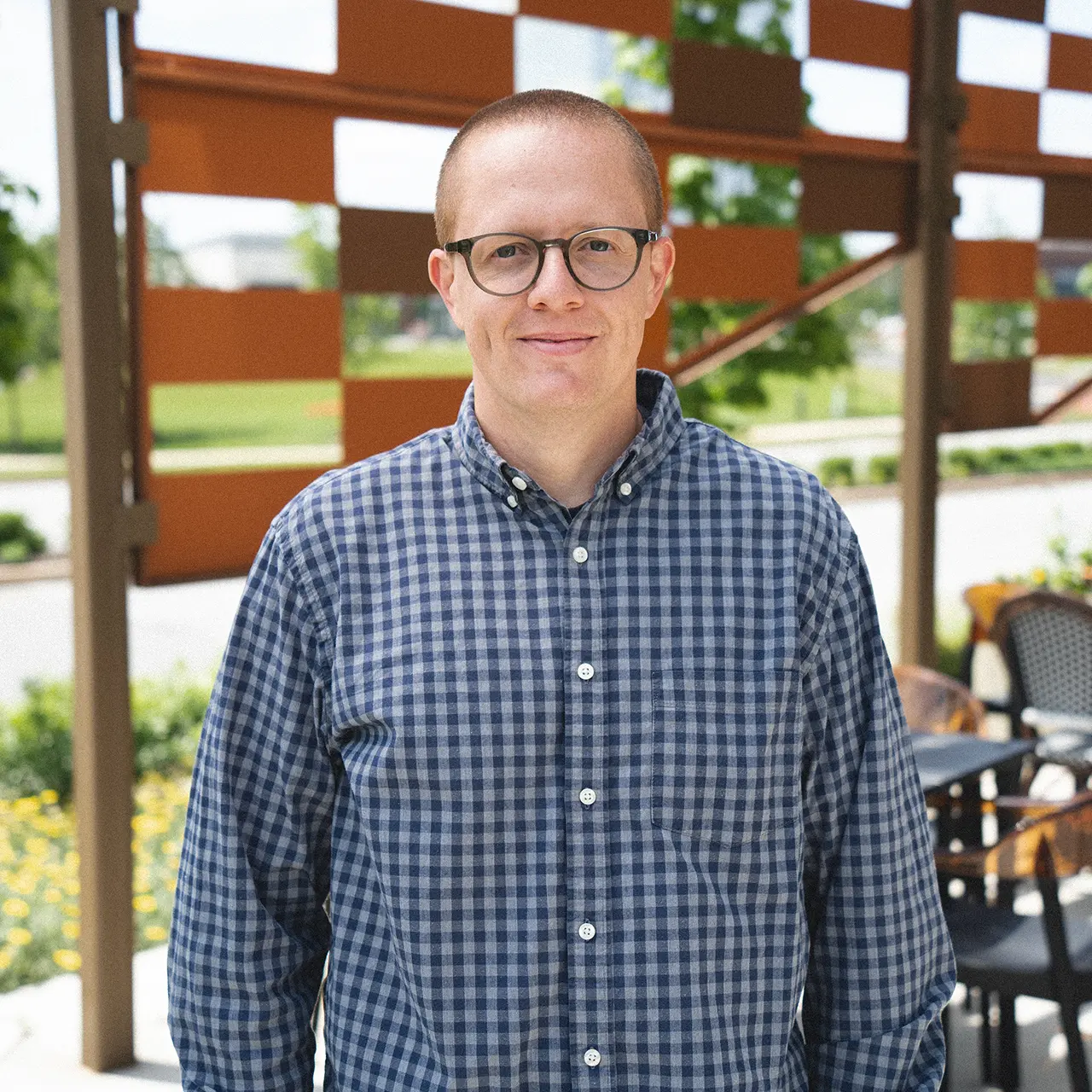 Hayes Parnell is smiling and wearing a blue plaid shirt.