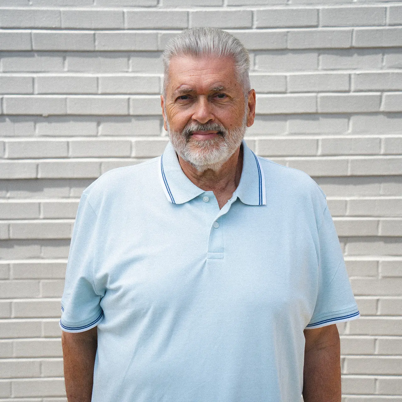 Len Armstrong is smiling and wearing a light blue shirt.