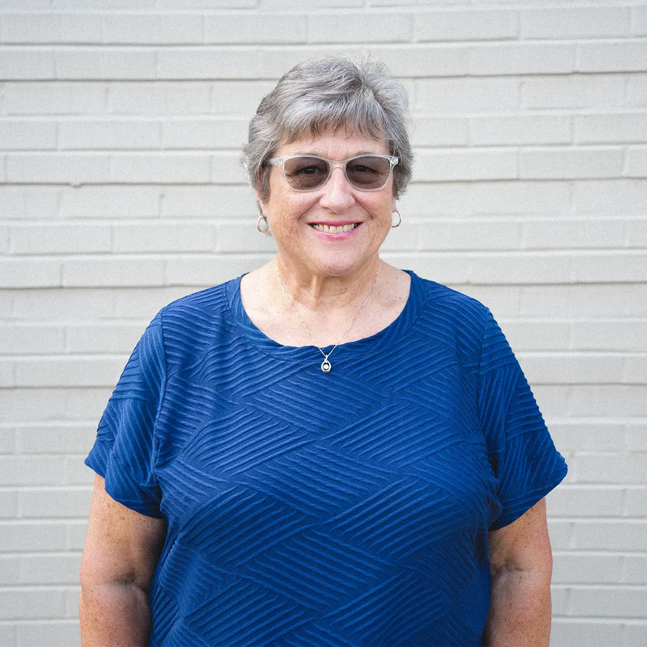Maria Ash is smiling and wearing a blue shirt.