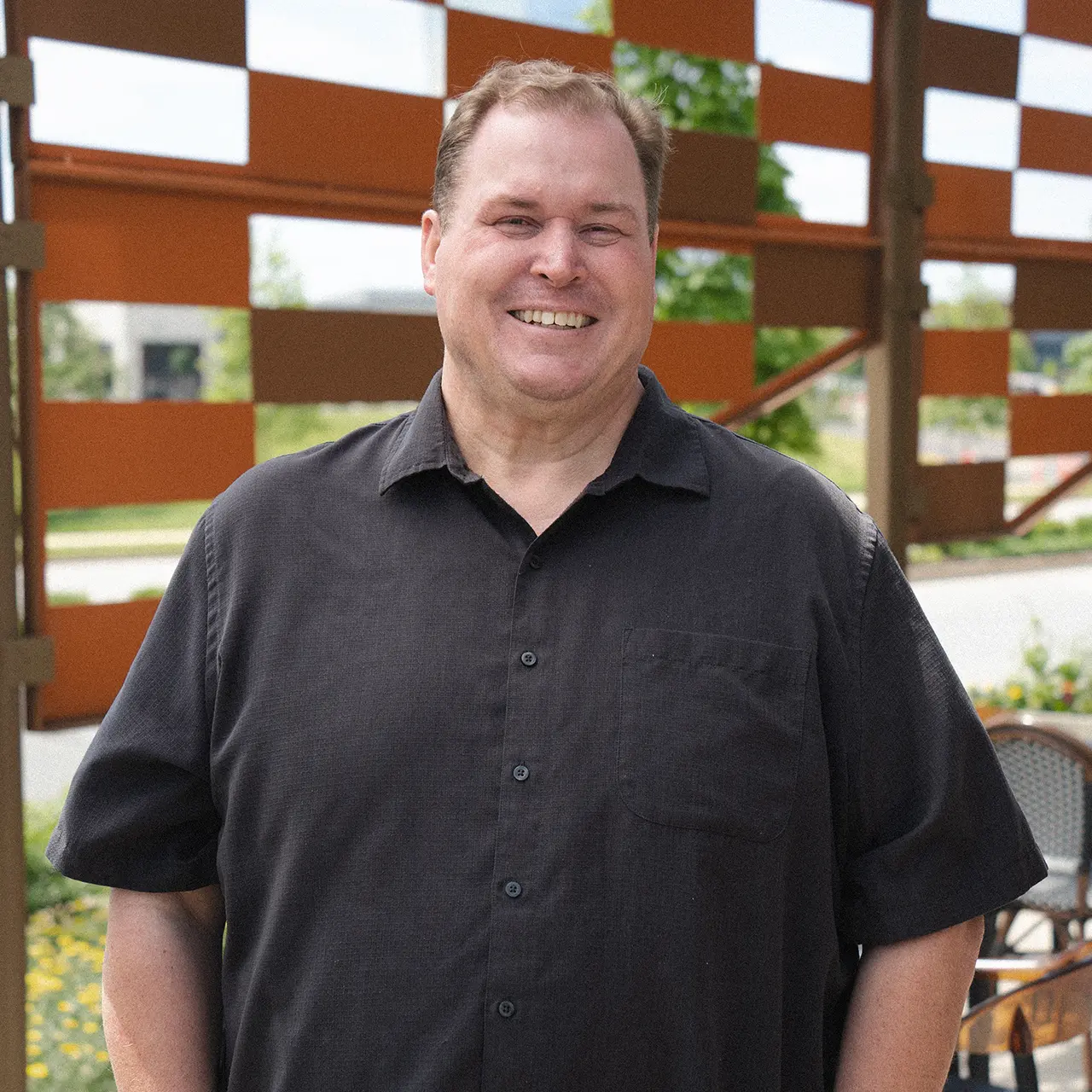 Matthew McNutt is smiling and wearing a black shirt.