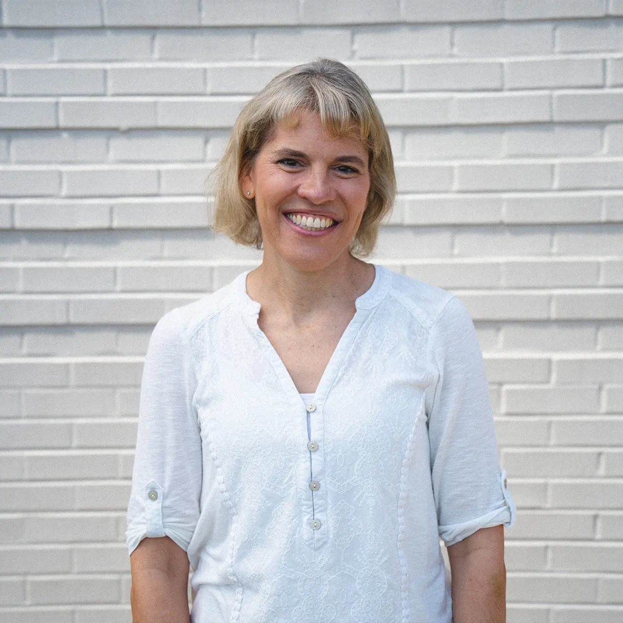 Rochelle Anderson is smiling and wearing a white shirt.