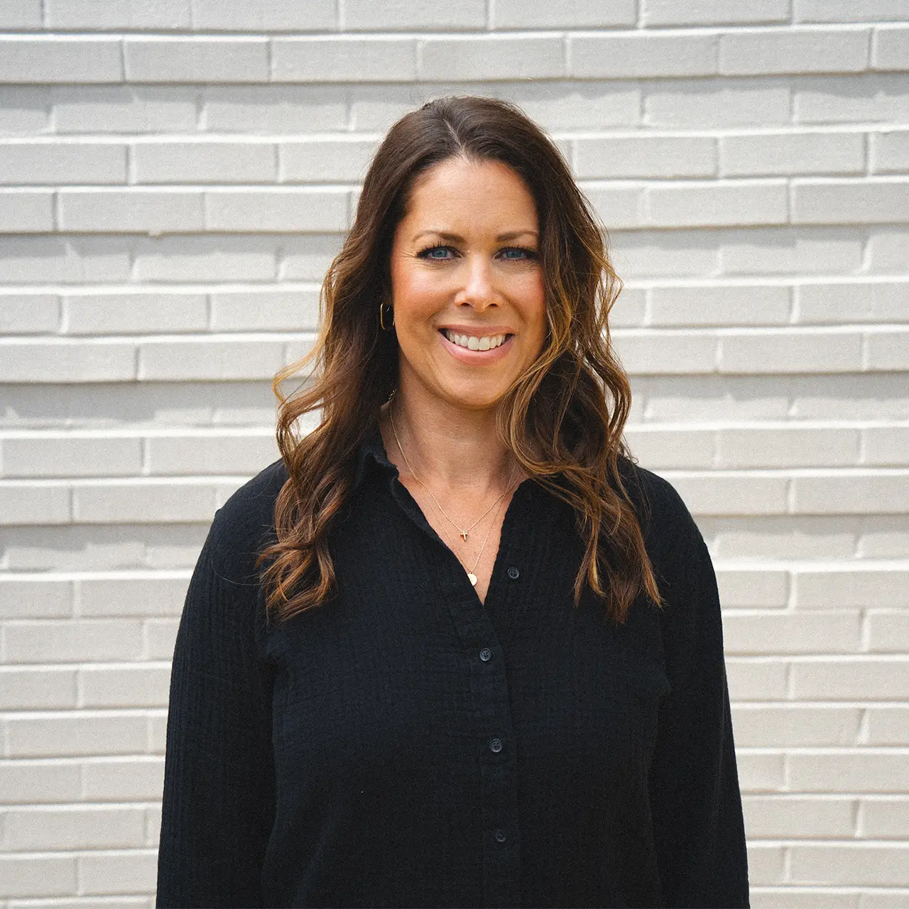 Shannan Keeler is wearing a black shirt and smiling.